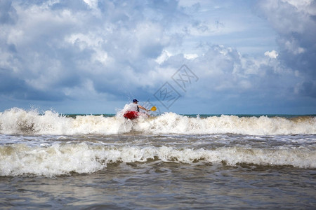 度假时在海里划独木舟冲浪的人图片