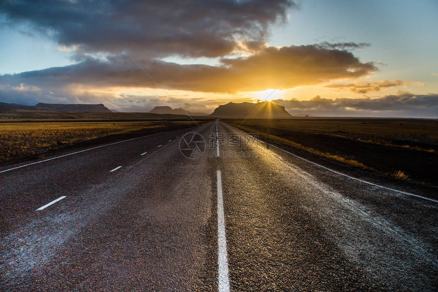 通过冰岛景观的道路公路和汽车旅行风景和日落公路旅行概念图片