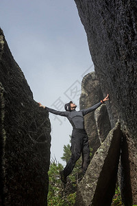 攀岩者爬上冰岛海岸的黑岩石墙上背景图片