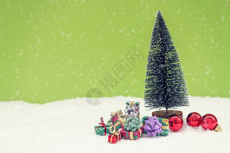 圣诞树与彩色礼品盒在雪地里绿色背景的缩影圣诞图片