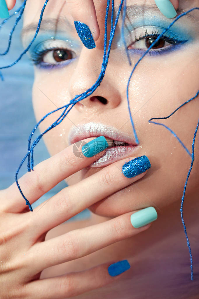 一个年轻女孩的图像蓝色化妆品和修甲用沙发闪亮多彩的指甲设计头部图片