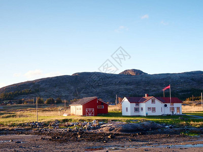 传统渔村岛上岩石海岸的乡镇红白色建筑在春日温暖背景图片