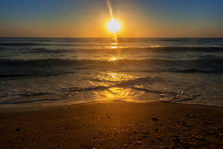 平静的海面和沙滩上的日出图片
