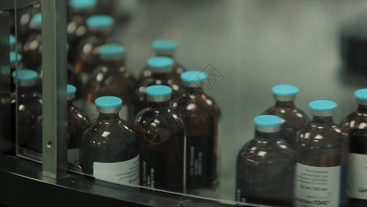 医药行业生产线机器输送机在工厂与瓶子液体药物的制图片