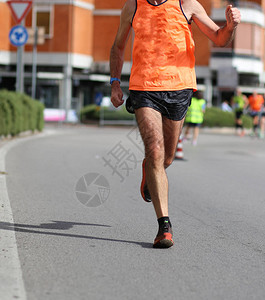 跑步者在城市马拉松比赛中跑步时的腿图片