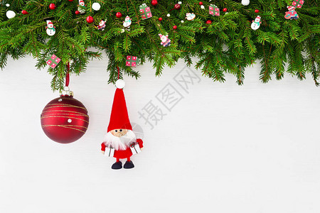 圣诞节背景圣诞枞树枝与圣诞老人和白色木制背景上的红色圣诞球复制图片