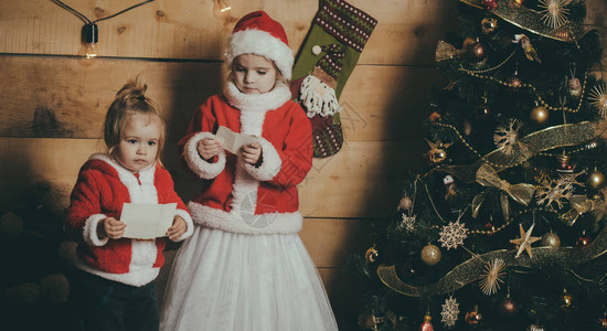 童年的圣诞老人孩子在圣诞树上寒假和期圣诞快乐的孩子们戴图片