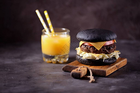 健康黑汉堡加牛肉冰山沙拉番茄片和干酪奶背景图片