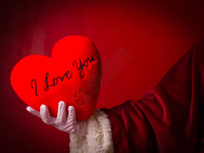 圣诞老人的手用红色心形枕头刺绣词我爱你图片