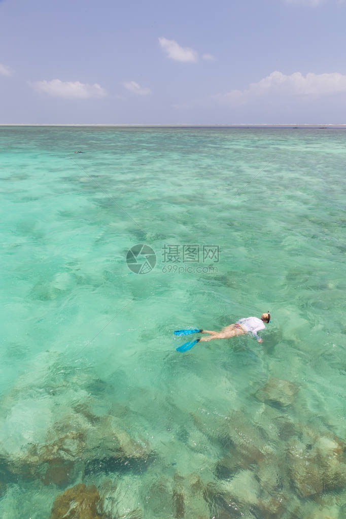 女人在热带泻湖清澈的浅海中浮潜图片
