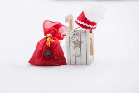 冬季假日背景红袋和圣诞礼物靠近木制雪图片