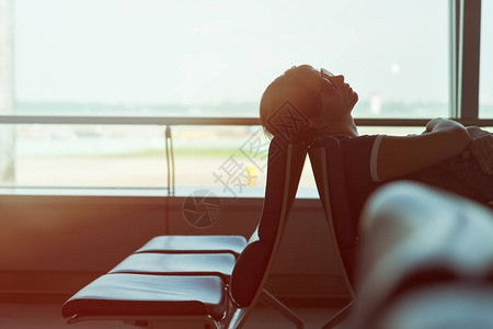 疲倦的白种女人睡在机场休息室在旅途中等待航图片