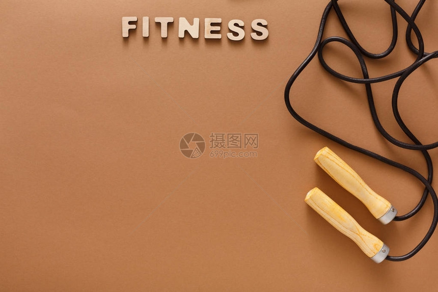 棕色背景上的健身词和跳绳跳绳运动用品减肥减肥概念顶视图片