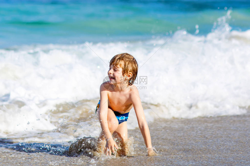 在佛罗里达州的海滩上玩的小金发孩子男孩图片