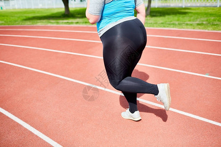 超重女在体育场跑步时图片