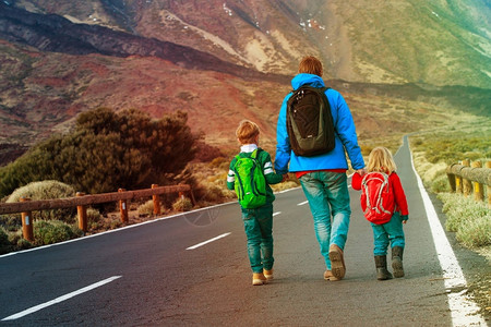 父亲和两个孩子在路上走路图片