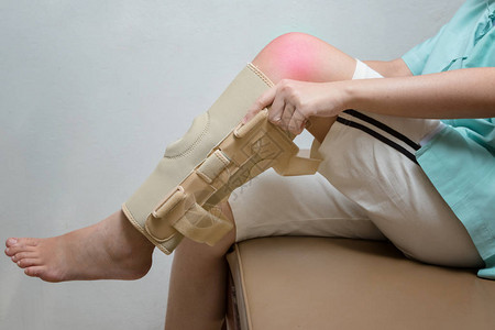 在康复无锡体育中心中佩戴弹膝撑的受伤妇女背景图片