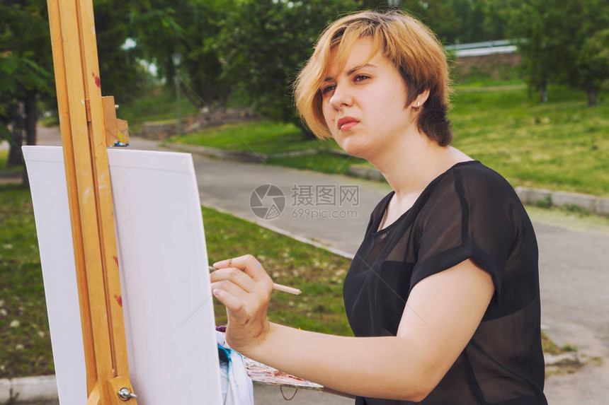 艺术家年轻女子在画布上画城市风景是城市公图片