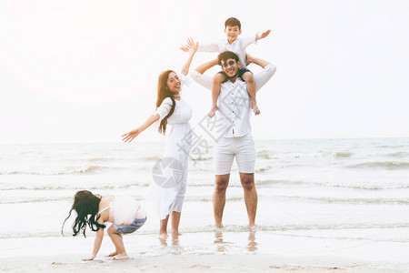 快乐家庭的父亲母亲和孩子去度假在热带沙滩在夏天图片