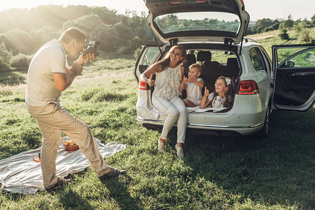 成人夫妇和他们的孩子在城外的公园野餐家庭周末概念四人享受夏天图片