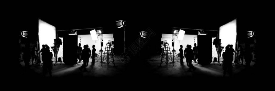 视频制作的剪影图像在幕后或b卷或制作电视商业电影电影船员团队莱特曼和摄影师一起在大工作室与导演一起工作的专业设备背景图片