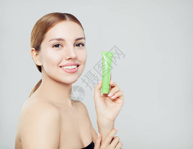 美丽的微笑的女人与润肤霜管美容皮肤护理和面部护理概念图片