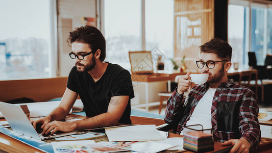 两位平面设计师的肖像享受工作专注于创意项目的专业插画师坐在工作场所喝咖啡休息团队合背景图片