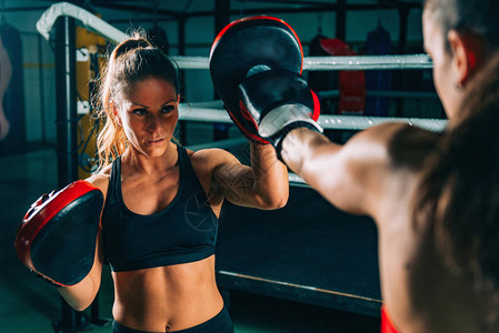 功能强大两个女人在健身房拳击训练的肖像背景