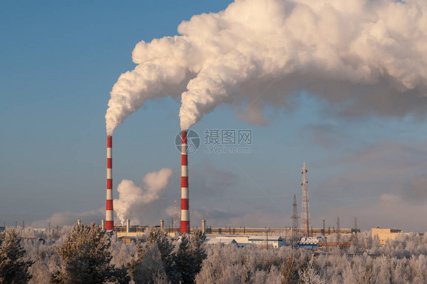 在寒冷的冬天火电厂的管道火电站高管道产生的白色浓烟在寒冷的冬日白色的蒸汽在蓝天上图片