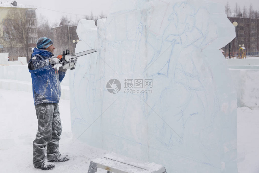 雕塑家在圣诞节用电锯把冰块图片
