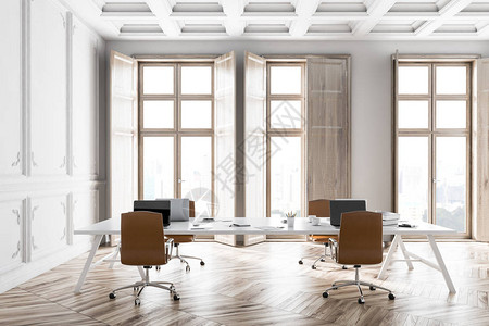现代办公室内装有白色墙壁木地板大白桌子和膝上型笔记本电脑图片