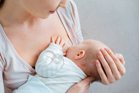 年轻女子用灰色母乳喂养婴儿图片