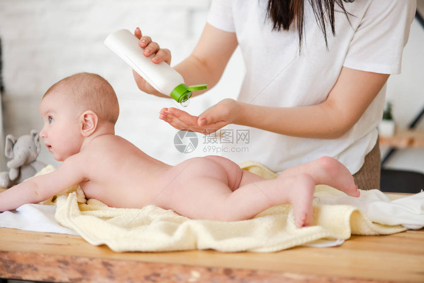 妈妈在婴儿的皮肤上涂了润肤油图片