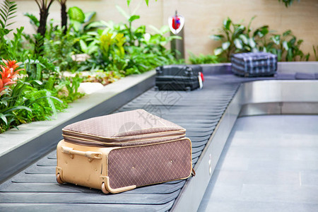 传送带上的手提箱在机场行李提取区被绿色背景图片
