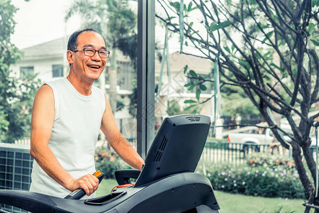 老年人在健身中心的跑步机上锻炼图片
