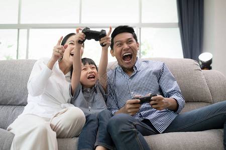 年轻的家庭父亲母亲和儿子看电视和玩游戏图片