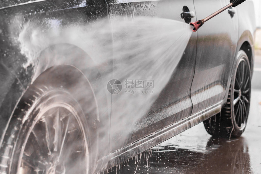 一个男人正在自助洗车店洗车高压洗车机喷泡沫图片