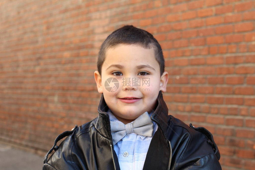 可爱小男孩耳领弓带和黑皮夹图片