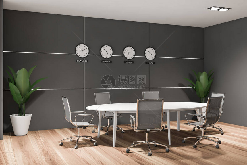 未来派会议室的角落有灰色的墙壁木地板圆形会议桌白色金属椅子和显示世界时间的时钟图片