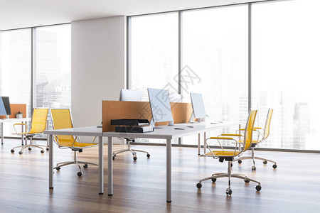 全景开放空间办公室的内部有白墙木地板舒适的白色电脑桌黄色椅子和窗户图片