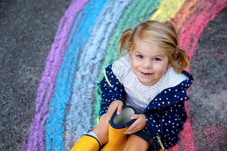 在地上用彩色粉笔画着彩虹图片