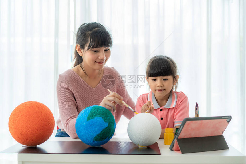 亚洲小学生与母亲在科学课上画月亮图片