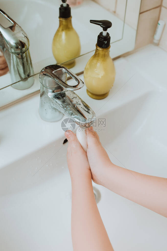 儿童在自来水龙头下使用肥皂和洗手图片