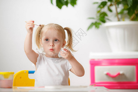 可爱的女婴学习水彩画蹒跚学步的小孩在家里用彩色画笔健康快乐的女儿在家里或托儿所背景图片