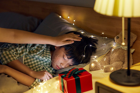圣诞儿童家人抚摸熟睡的男孩背景