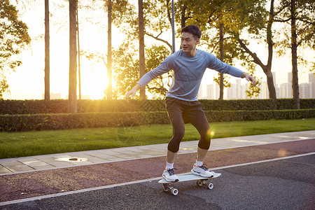 滑滑板男生夕阳下男青年玩滑陆冲板背景