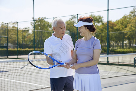 网球场交流沟通的老年夫妻图片