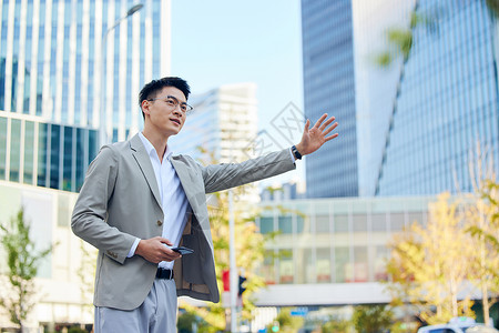 户外商务年轻商务男士路边等待打车形象背景