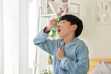 儿童睡衣使用哮喘喷雾治疗的男孩背景