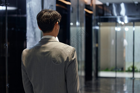 年轻商务男性下班等电梯背影图片